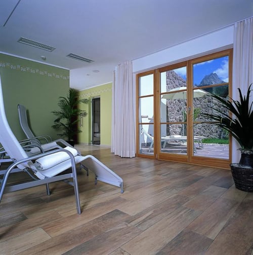 Moderner Spa-Entspannungsraum in den Rustclea Apartments in Selva di Valgardena mit Liegen und Bergblick