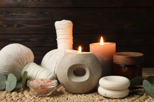Spa wellness setup with massage stones, salt, candles and eucalyptus at Rustclea Apartments, Selva di Valgardena