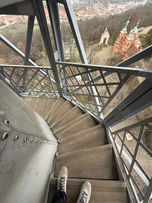 Aerial staircase view from Golden Mermaid Villa in Ribeirinha, Portugal, overlooking red-roofed church and forested landscape