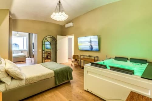 Suite moderna di lusso a Roma con letto, tavolo da biliardo, TV e pareti con accenti verdi