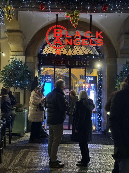 Black Angels bar entrance at Hotel U Prince during holiday season with festive lights and decorations