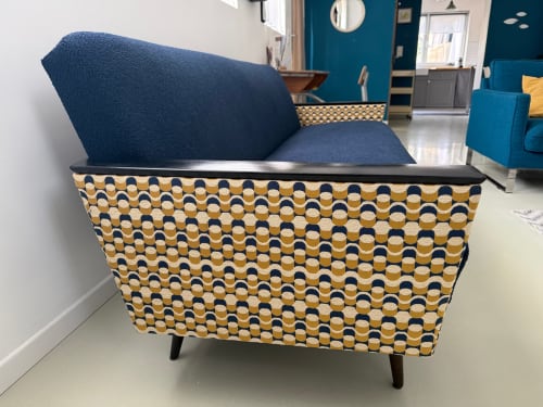 Modern armchair with geometric patterned base and blue cushions at l'Atelier des Dépendances, Lipsheim