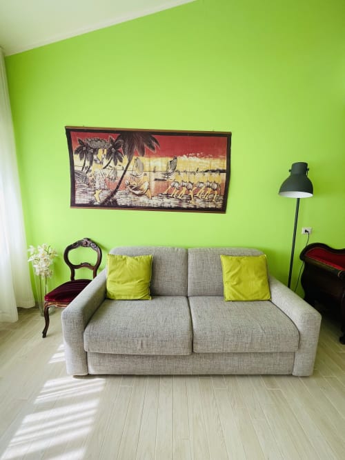 Bright lime green living room at Varenna by Foot with gray sofa, yellow pillows, framed coastal artwork, and modern black