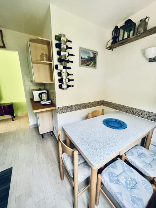 Cozy dining area at Varenna by Foot with wooden table, chairs, wine rack, and mountain view in Varenna apartment