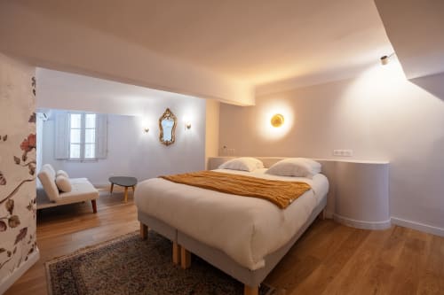 Modern bedroom in Suite Lucas de Montigny at Les Suites de Montigny, Aix-en-Provence, with queen bed, lounge area, and warm