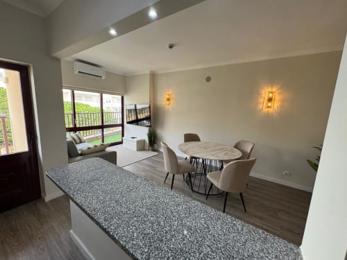 Interior moderno do Sweet Home Praia Mar em Portimão com sala de jantar, quarto e vista para piscina da varanda