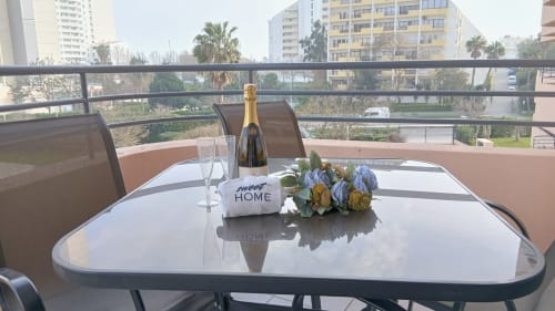 Sacada Sweet Home Portimão com champanhe, flores e vista da cidade do terraço do apartamento