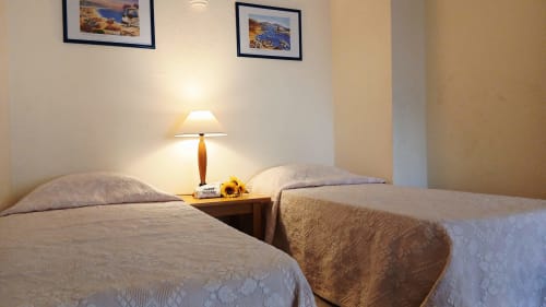 Quarto duplo do apartamento Sweet Home Paraiso Sol da Rocha em Portimão com luminária de cabeceira e arte costeira