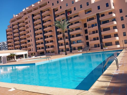 Piscina brilhante com prédio de apartamentos em terracota em Portimão, Portugal - Sweet Home Paraiso Sol da Rocha