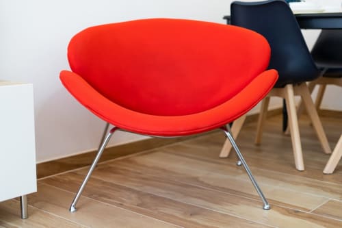 Silla de acentuación roja moderna con patas cromadas en la sala de estar de ML Apartments Valencia