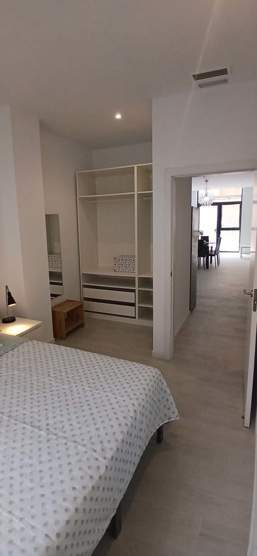 Dormitorio moderno con armario integrado, cama y distribución abierta en ML Apartments Valencia
