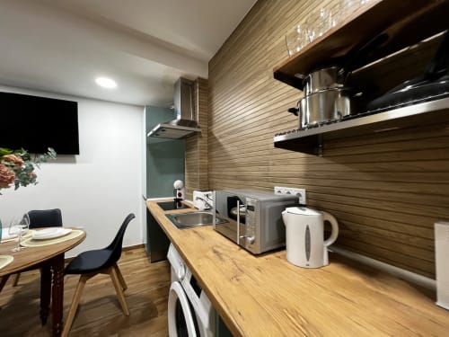 Cocina moderna en ML Apartments Valencia con encimeras de madera, electrodomésticos de acero inoxidable, comedor y luz natural