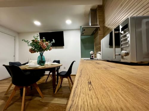 Cocina y comedor modernos en ML Apartments Valencia con encimeras de madera, electrodomésticos de acero inoxidable y sillas negras