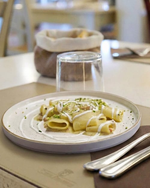 Elegant pasta dish at Corte Pellegrini B&B in Verona, Italy, featuring rolled pasta with cream sauce and garnish