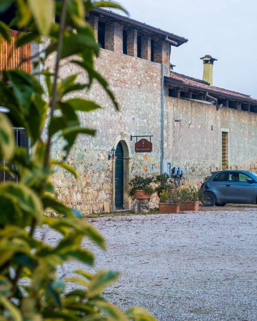 Corte Pellegrini stone villa with green door and parked car in San Martino Buon Albergo, Verona