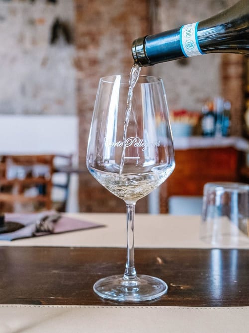 Prosecco being poured into branded glass at Corte Pellegrini, a bed and breakfast in Verona, Italy