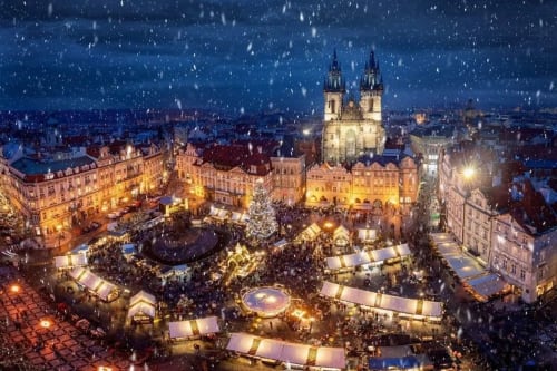 Prague Christmas market at night with snow, Church of Our Lady before Týn illuminated