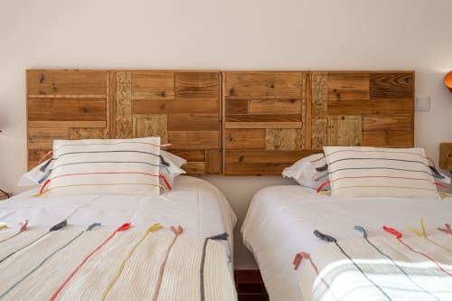 Duas camas com roupa de cama listrada e cabeceiras de madeira na Pousada Cerro da Campaniça em Santiago do Cacém