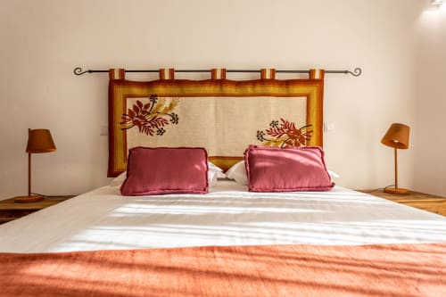 Quarto elegante em Cerro da Campaniça com cabeceira de madeira, almofadas rosa e vistas para o jardim em Santiago do Cacém