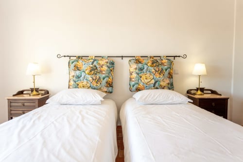 Camas de solteiro com roupas brancas e almofadas em almofadão floral no B&B Cerro da Campaniça em Santiago do Cacém, Portugal