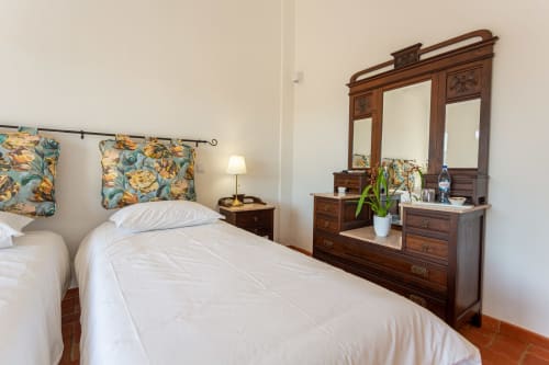 Quarto da Pousada Cerro da Campaniça em Santiago do Cacém com camas gêmeas, móveis de madeira e vista para o jardim