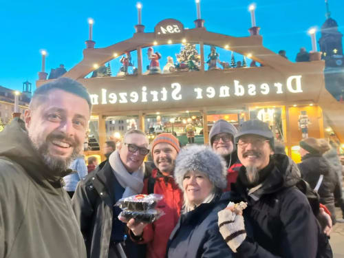 Group enjoying treats at festive Christmas market pavilion in Ribeirinha, Portugal