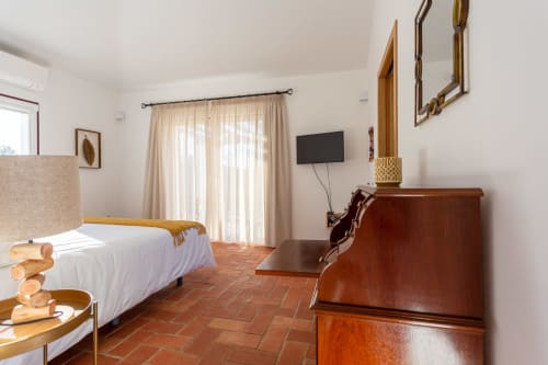 Quarto luminoso na Cerro da Campaniça B&B em Santiago do Cacém com cama branca, móveis em madeira e vista para o jardim