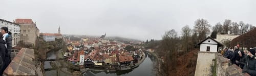 Panoramic view of Cesky Krumlov's historic town with red-roofed buildings and river below