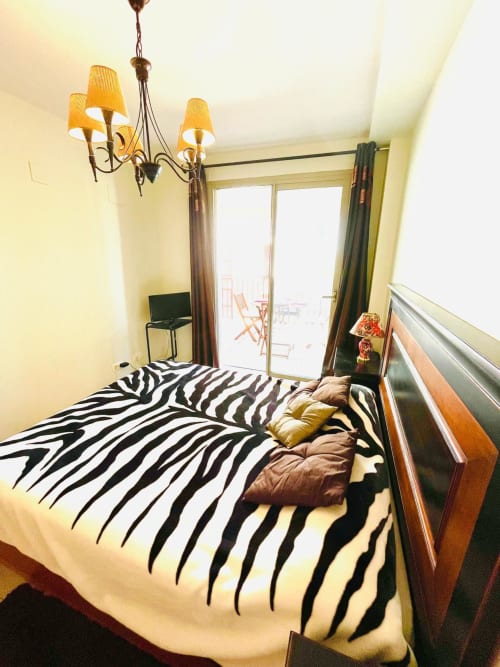 Lit à rayures zèbre dans l'appartement Sant Jordi avec vue sur balcon, éclairage suspendu et accès à la piscine