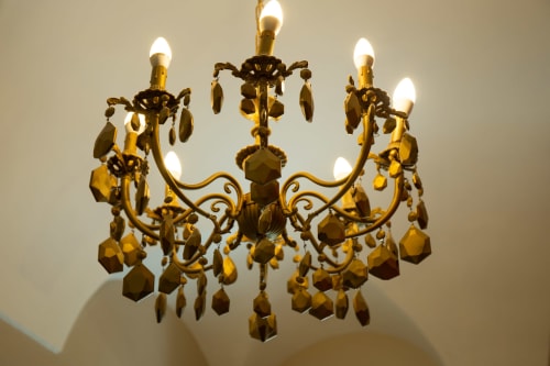 Lussuoso lampadario dorato con cristalli pendenti nella sala Lina di Casa Scola a Loano