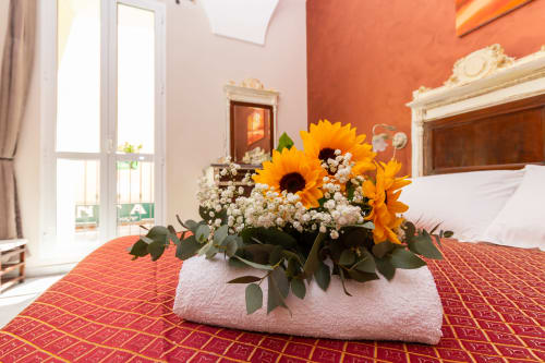 Vivace composizione di girasoli sul letto della camera Lina presso l'hotel boutique Casa Scola a Loano, Italia
