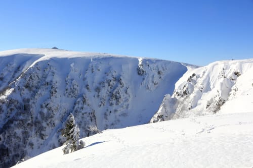 Snow-covered mountain peaks with forested slopes near Granges-Aumontzey, France