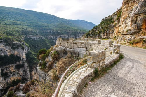 Scenic mountain road with stone railings overlooking lush valley near Granges-Aumontzey, France