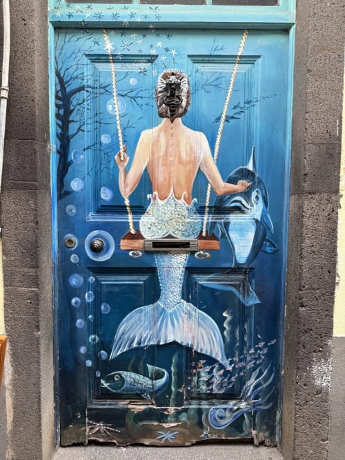 Arte de porta com tema de sereia na pousada Golden Mermaid Villa em Ribeirinha, Portugal, apresentando cena subaquática com balanço