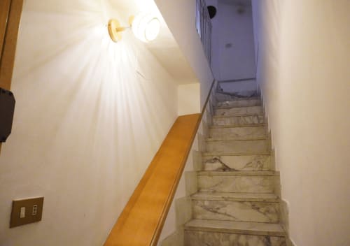 Scala con corrimano in legno nell'appartamento Di Leonardo BnB, Velletri. Corridoio illuminato con pareti bianche.