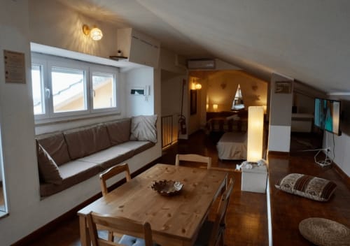 Ampio loft a Velletri con zona living open-plan, tavolo in legno, angolo relax marrone e design moderno