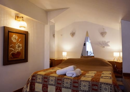 Camera accogliente al Di Leonardo B&B a Velletri con letto in legno, asciugamani bianchi, illuminazione calda e vista sulla città