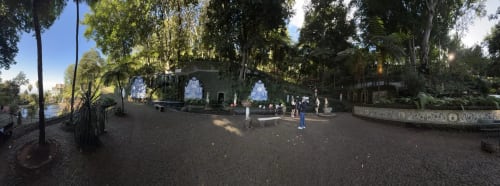 Pátio sombreado na Villa Golden Mermaid em Ribeirinha com árvores altas, área pavimentada e hóspedes apreciando o tranquilo jardim