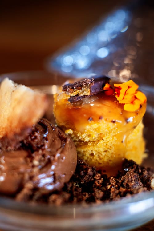 Postre de chocolate gourmet con flor amarilla como decoración en Casa Grande do Soxal, Oza-Cesuras