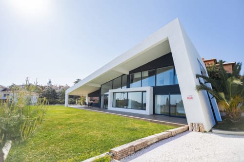 Exterior del moderno hotel BH Marbella con arquitectura minimalista blanca, grandes ventanales y jardines diseñados en día soleado