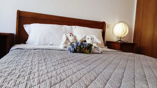 Quarto aconchegante do apartamento Sweet Home Portas da Rocha em Portimão com cama de madeira, almofadas brancas e brinquedos de pelúcia decorativos