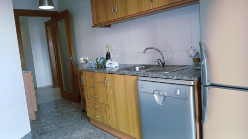 Cozinha moderna com armários de madeira e bancada de granito no apartamento Sweet Home Portas da Rocha, Portimão