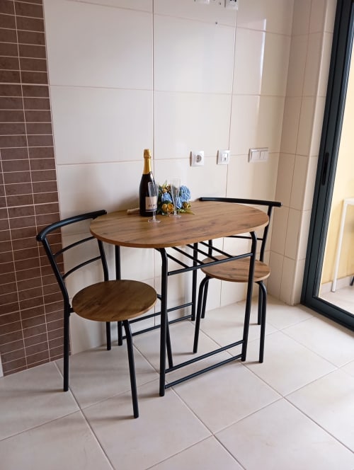 Conjunto de jantar moderno com mesa de madeira e cadeiras pretas no apartamento Sweet Home Borralha, Portimão