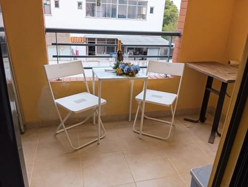 Área de estar na varanda do apartamento Sweet Home Borralha em Portimão com duas cadeiras, mesinha e vista para a cidade