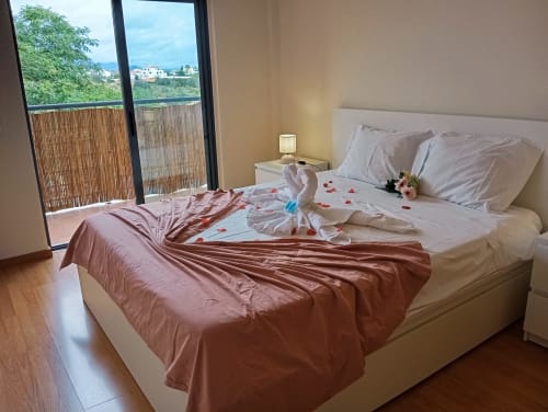 Quarto romântico no apartamento Sweet Home Borralha, Portimão, com vista para a cidade, decorado com cisnes em toalhas e pétalas de rosa