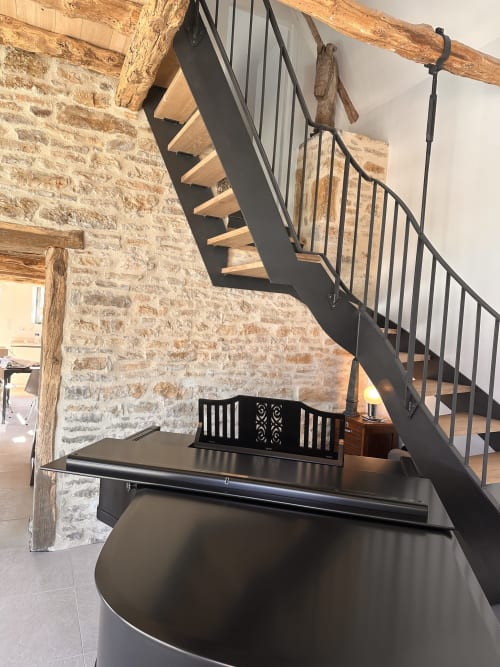 Escalier noir contemporain aux marches en bois dans l'intérieur en pierre du Gîte l'Harmonie du Causse