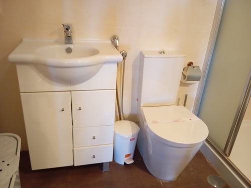 Banheiro moderno com pia branca, vaso sanitário e bidê no apartamento Sweet Home Vila Rosa em Portimão