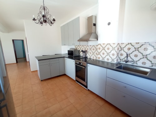 Cozinha moderna do apartamento em Sweet Home Inn Terrace, Portimão com armários brancos, eletrodomésticos em aço inoxidável e decoração
