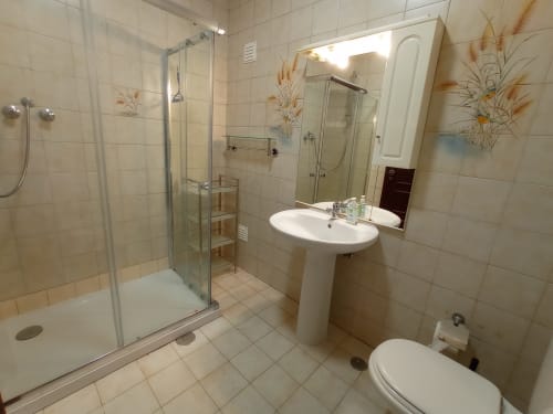 Banheiro moderno com chuveiro, pia com pedestal e toilete no apartamento Sweet Home Inn Terrace em Portimão