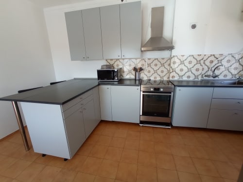 Cozinha moderna no apartamento Sweet Home Inn Terrace em Portimão, com armários cinza, eletrodomésticos em aço inoxidável e ilha
